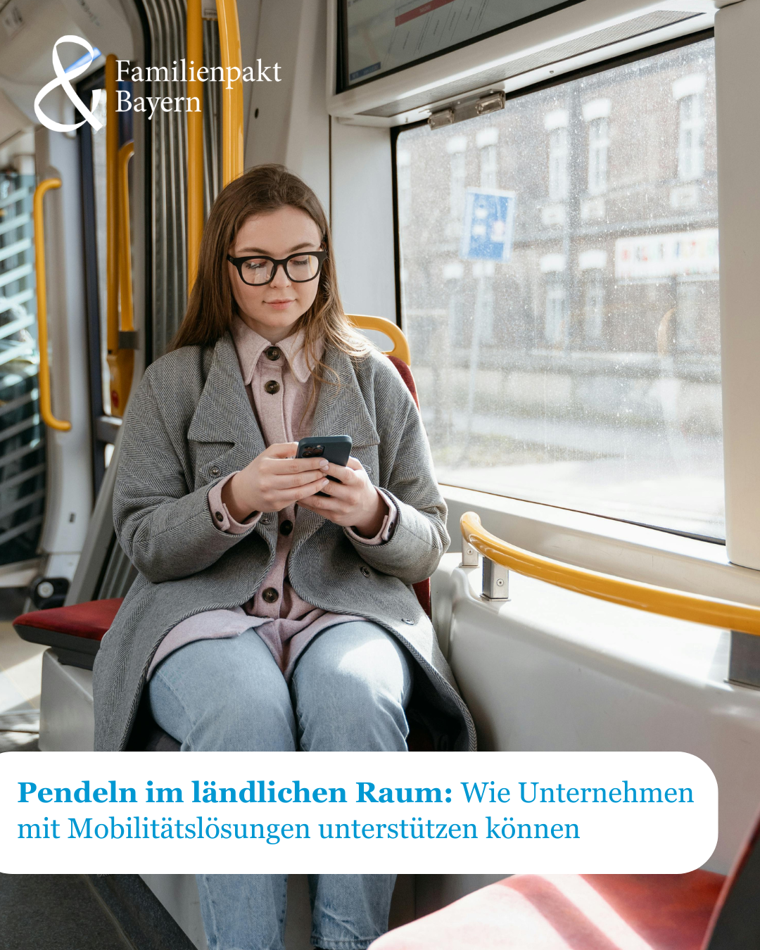 Eine Frau in der Straßenbahn schaut auf ihr Handy