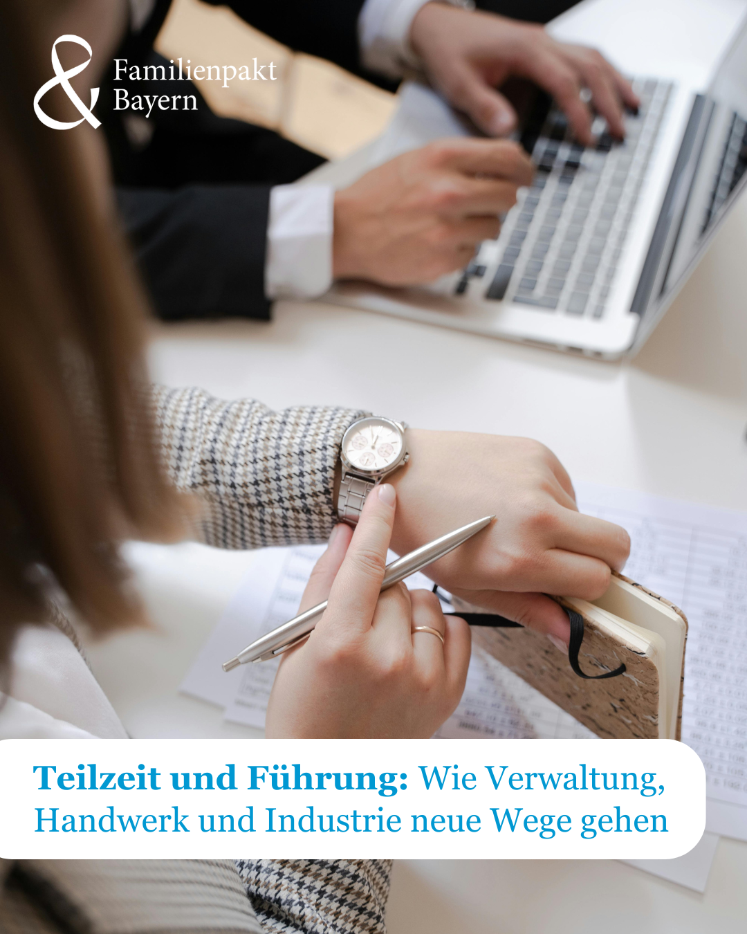 Eine Frau und ein Mann am Schreibtisch im Büro, die Frau schaut auf ihre Armbanduhr