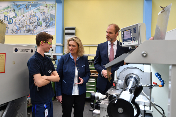 Arbeitsministerin Kerstin Schreyer mit einem Auszubildendem (li.) und Lars Wagner (re.), Vorstand Technik der MTU Aero Engines AG ©MTU Aero Engines