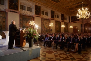 Staatssekretär Johannes Hintersberger eröffnet die Veranstaltung im vollbesetzten Kaisersaal der Residenz München.
